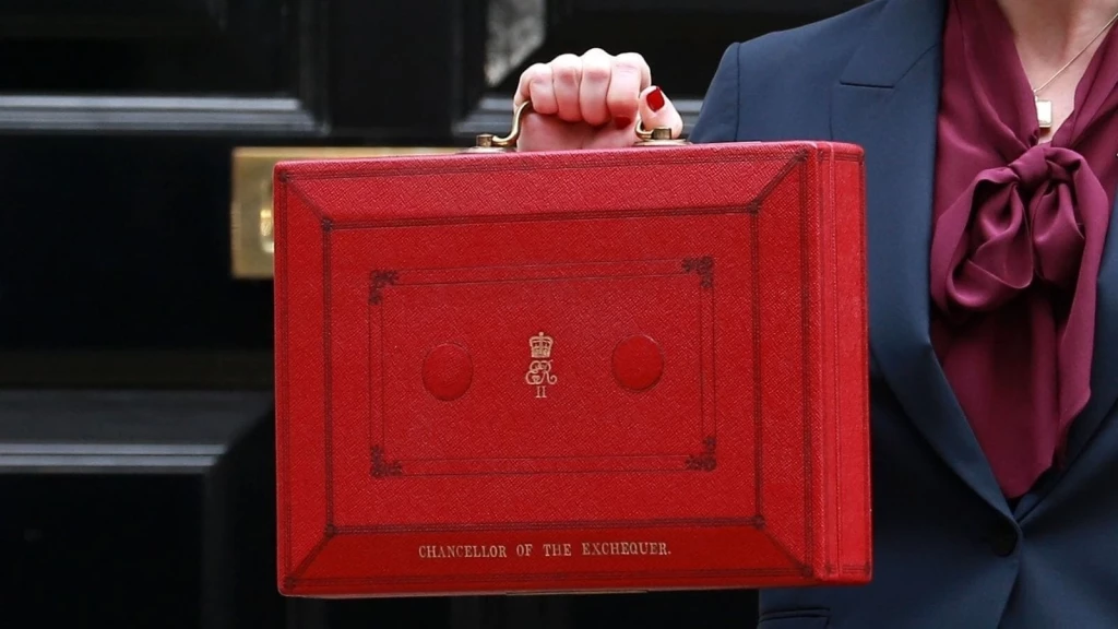 Red UK Budget briefcase being held outside a government building, symbolising the Autumn Budget 2025 and its impact on property developers, landlords, and planning reform.