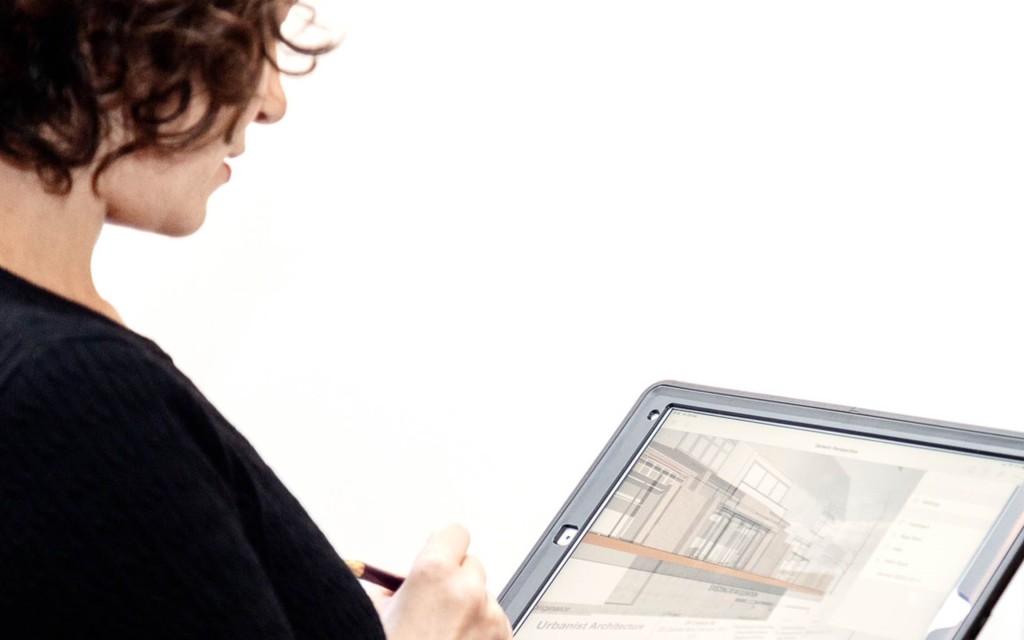 London interior designer working on architectural plans using a tablet, showcasing the integration of modern technology in interior design. The image highlights the detailed and precise approach taken by top London interior designers to create stunning and functional living spaces.
