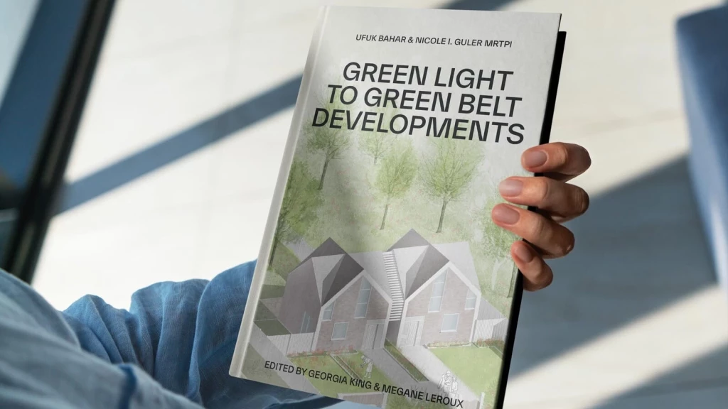 A person holding a book titled "Green Light to Green Belt Developments," written by Ufuk Bahar and Nicole I. Guler MRTPI. The book cover features a design of modern housing set against a backdrop of trees, symbolising development within Green Belt land. This image is ideal for promoting discussions around Green Belt policy, sustainable housing developments, and urban planning. Perfect for those seeking insights into navigating the complexities of Green Belt rules, key purposes, and planning permission processes.