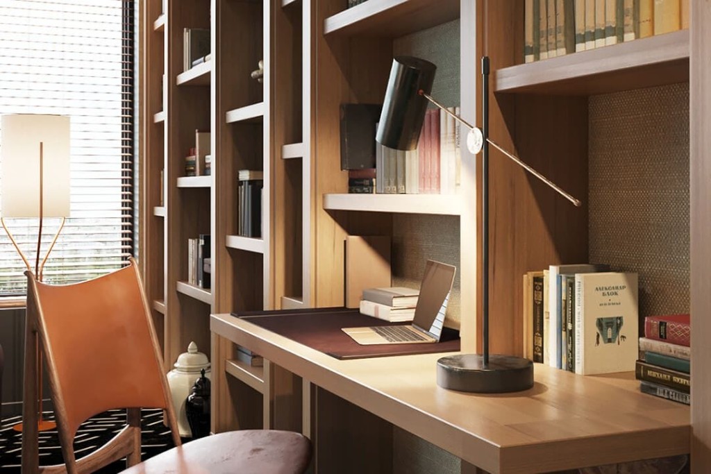 Wooden interior design for office space with asymmetric wall mounted bookshelf with attached desk, matching wood and leather desk chair and wooden window blinds 