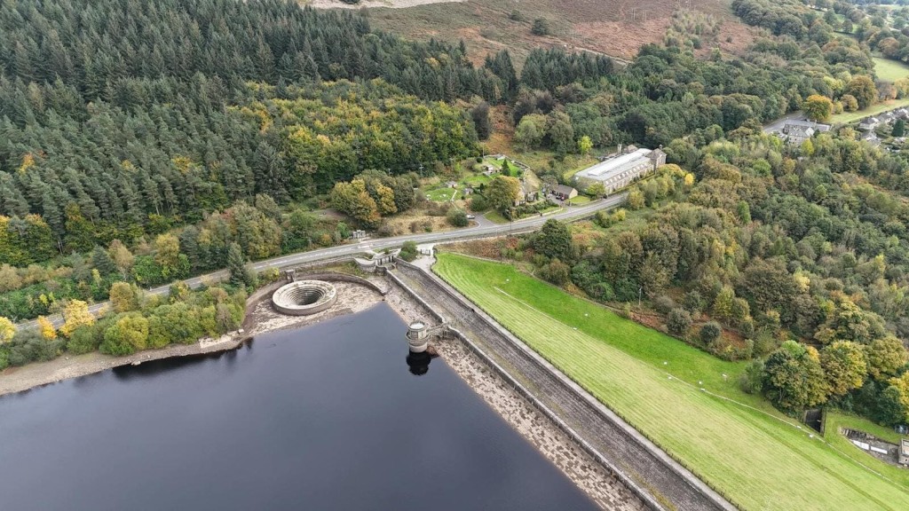 An aerial view of a Green Belt area featuring a reservoir, dense woodland, and open fields, demonstrating the potential for sustainable data centre developments in natural landscapes.