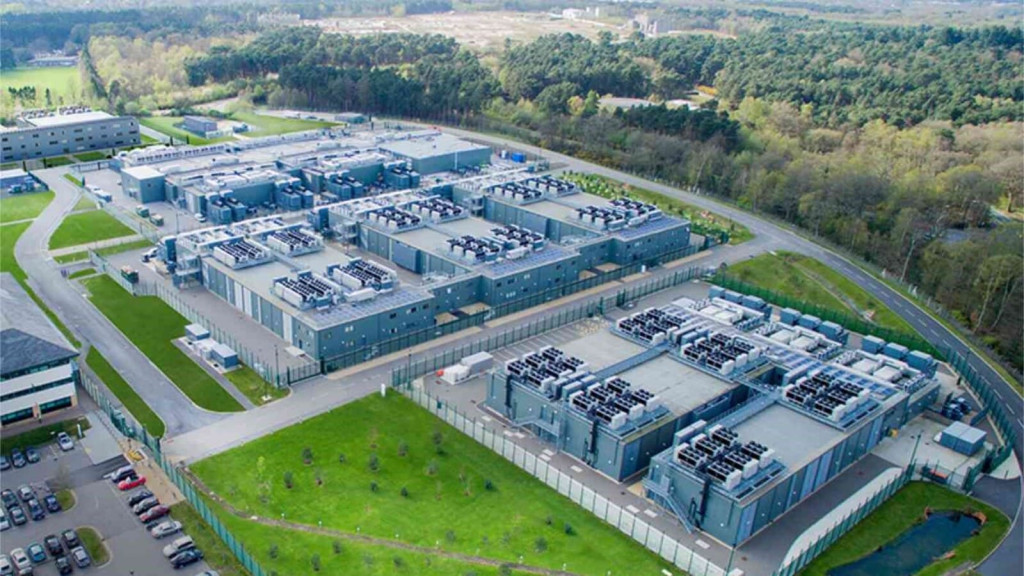 An aerial view of a modern data centre located in Farnborough, Hampshire, surrounded by Green Belt land, integrating advanced infrastructure with natural greenery.