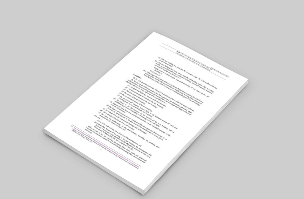 Close-up of a printed document outlining regulations for permitted development under Class ZA in the UK, including conditions and restrictions for demolishing buildings to construct new residential properties without planning permission.