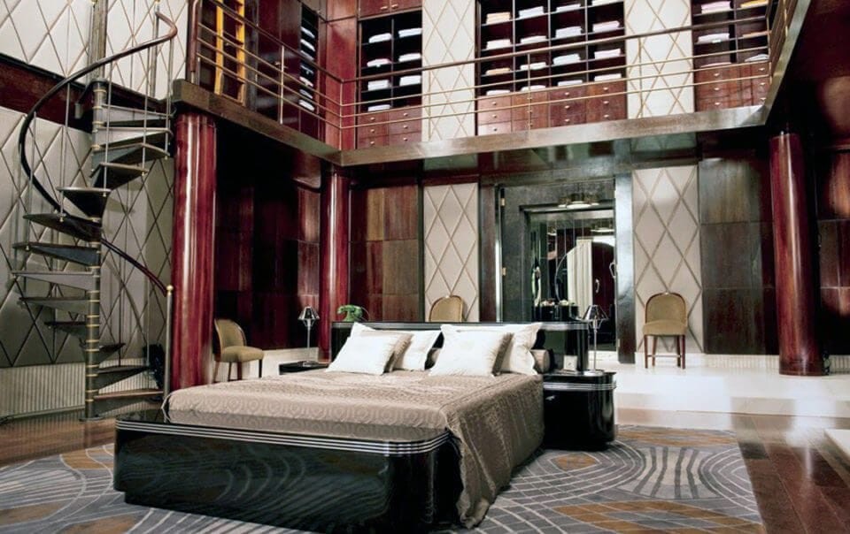 Art deco interior design of Jay Gatsby's bedroom in the latest Baz Luhrmann film with dark red accent pillared room with a interior second storey accessing a walk-in closet and geometric patterned wall details