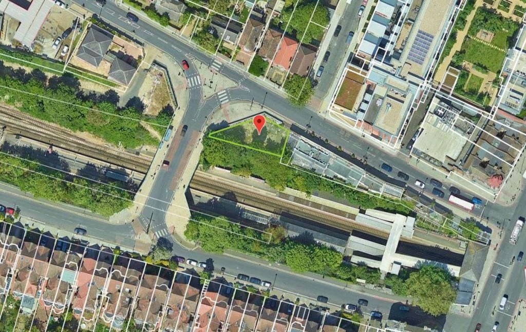 Aerial view of a small urban development site near Streatham Hill Station, marked with a red pin, showing surrounding roads, residential houses, and railway tracks, highlighting the potential for infill development.