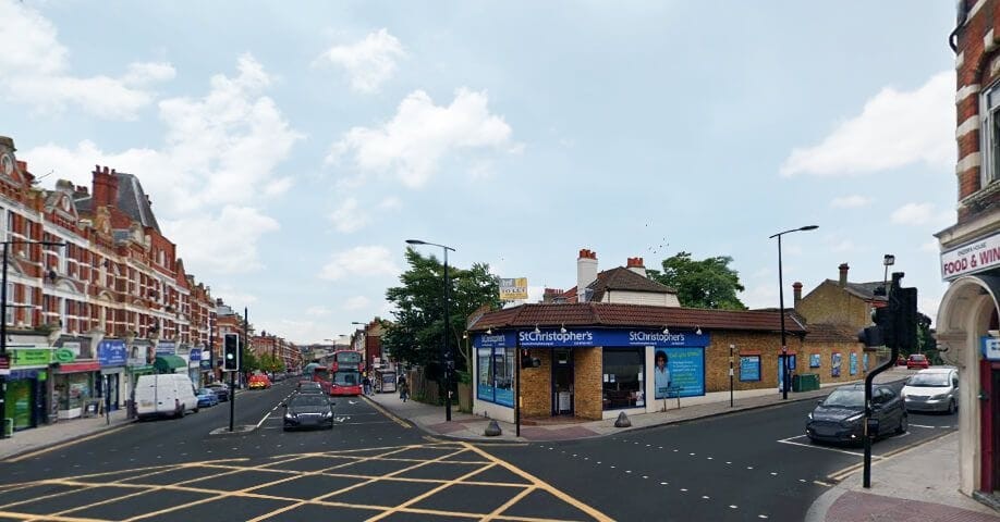 Urban street scene with a corner shop and traffic, highlighting potential for upward extensions to add flats above retail spaces without planning permission.