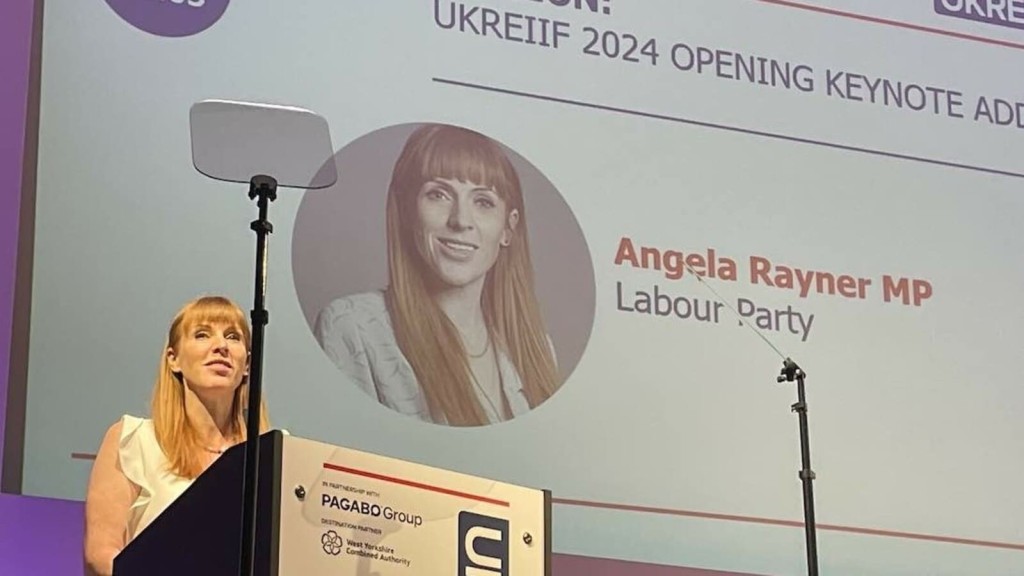 Angela Rayner MP delivering the opening keynote address at the UKREiiF 2024 conference. The image captures Rayner speaking at the podium, discussing Labour's plan of actions for Green Belt reform.