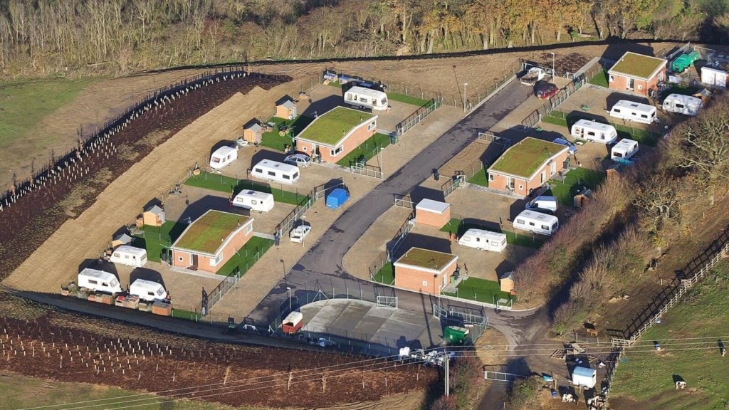 Aerial view of a permanent accommodation site in the green belt, providing residential space for the gypsy and traveller community, with clear boundaries and structured plots.