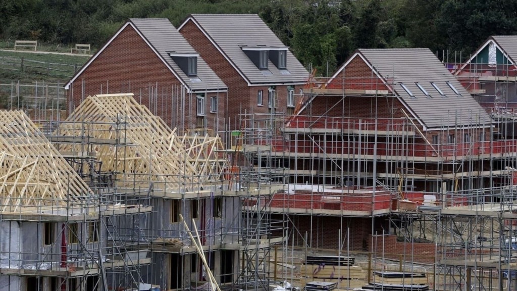 Construction site with partially built houses, illustrating the development of new residential areas within the Green Belt. The image highlights the construction process and the potential for grey belt land to be used for housing, aligning with Labour's plans to address the UK's housing crisis.