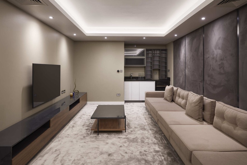 Modern and minimalist interior design of a large living room with a beige five-seater couch, a soft beige carpet and grey suede walls