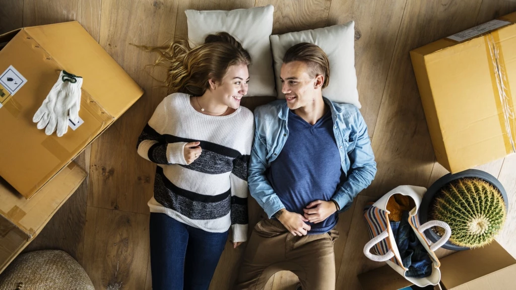 Young tenants settling into a newly converted HMO property, surrounded by moving boxes.