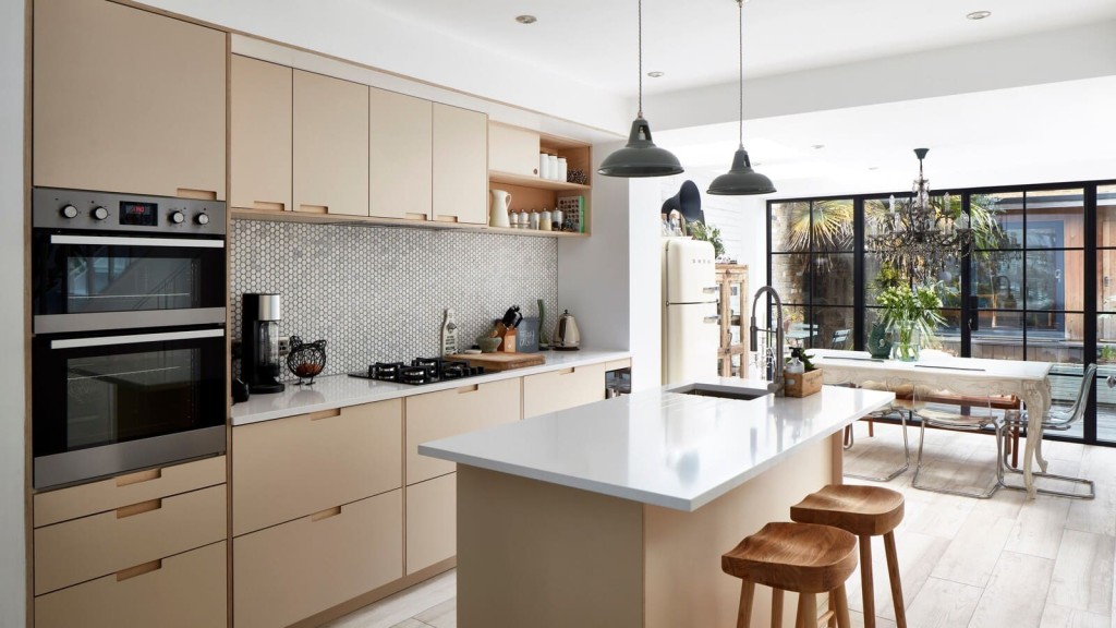 A contemporary open-plan kitchen with seamless interior design, featuring cream cabinetry, crittall-style glass doors, and elegant interior architecture, perfect for house extensions