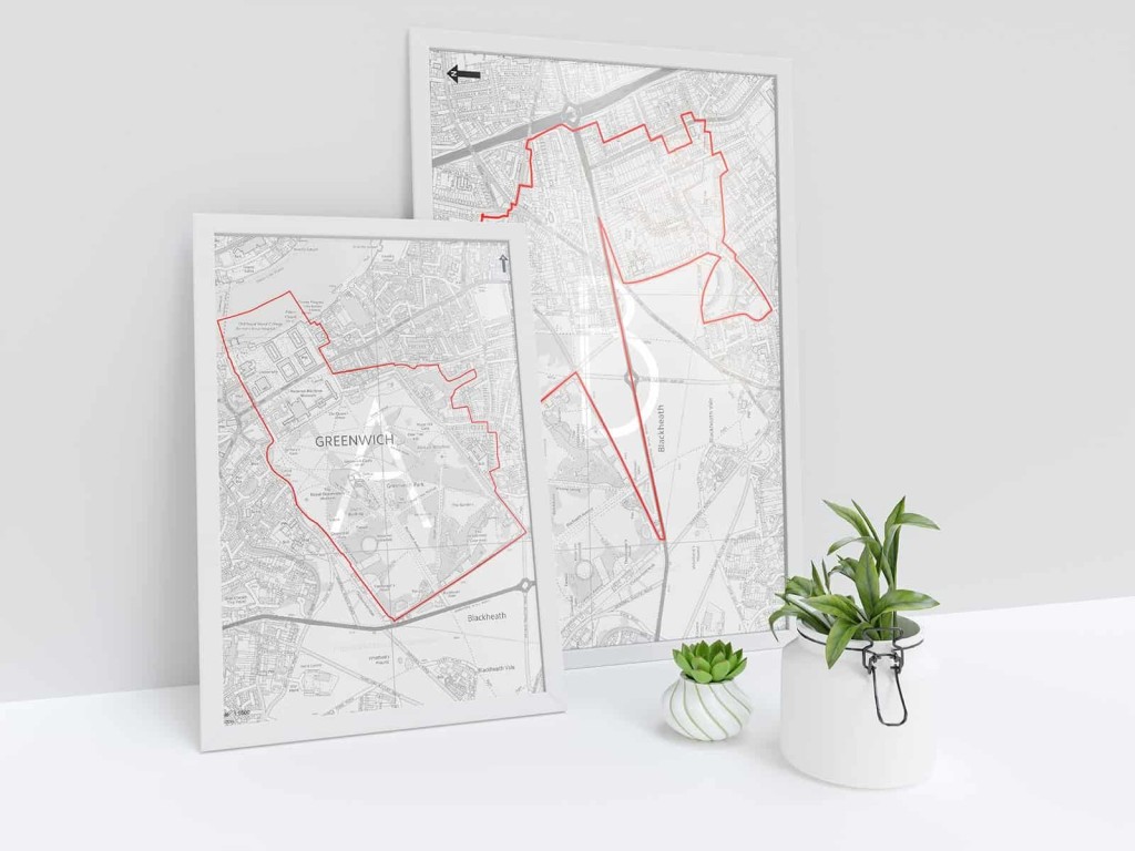 Two framed maps on a white surface with outlines of Greenwich conservation areas, accompanied by small green potted plants, showcasing urban planning and the importance of preserving historical urban landscapes.
