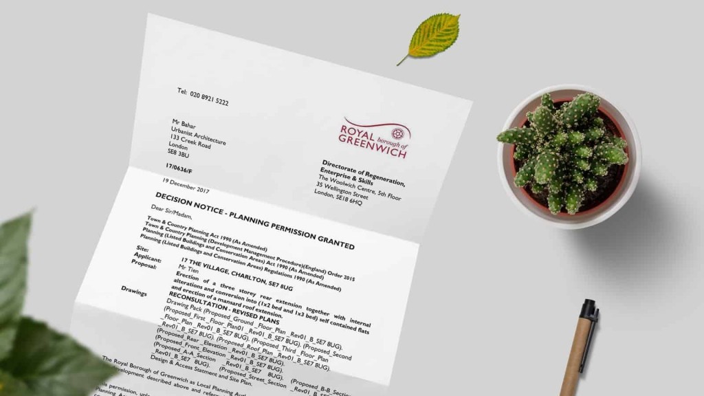 A planning permission granted notice from the Royal Borough of Greenwich on a white surface with a contact number at the top, next to a fresh green leaf and a potted cactus, indicating successful architectural approval for a project.
