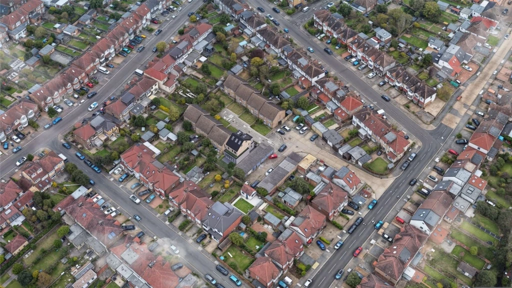 A Google Earth-style aerial view of a London residential neighbourhood showing a new infill family house introduced via CGI within an existing street block.