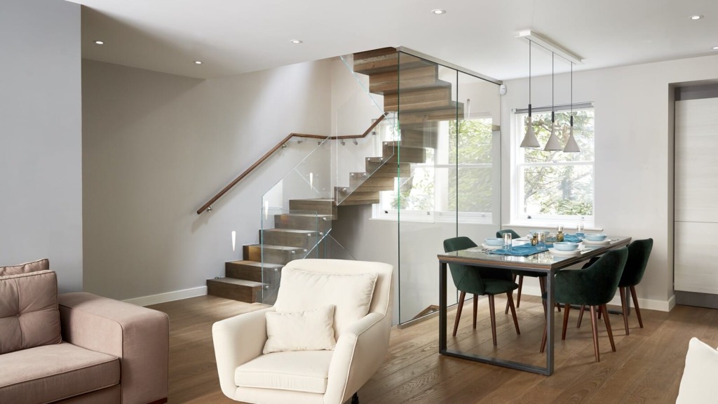Exquisite living and dining space in Central London adorned with a striking glass staircase, crafted by renowned architects for an unparalleled blend of luxury and modern design.