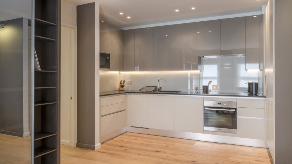 Modern grey-scaled kitchen showcasing a sink, microwave, and refrigerator in a stylish contemporary design.