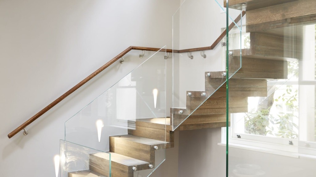 Iconic staircase design by a leading architectural firm in Central London, showcasing modern elegance with glass railing and wooden treads.