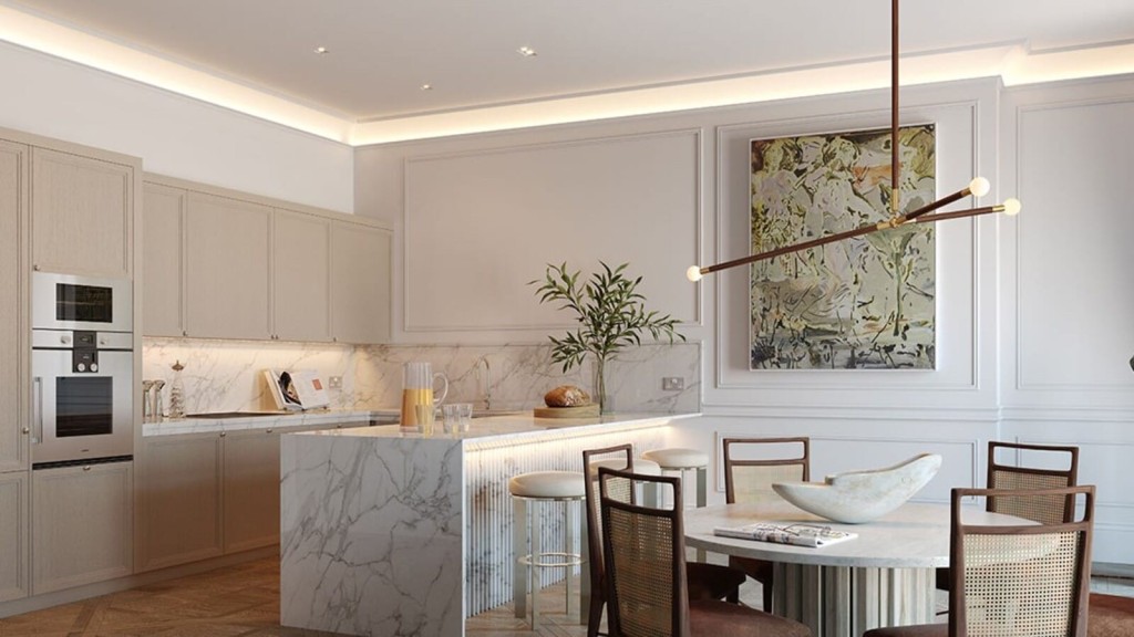 Exquisite kitchen with luxurious marble countertops and a dining table, enhanced by ample, luminous lighting.