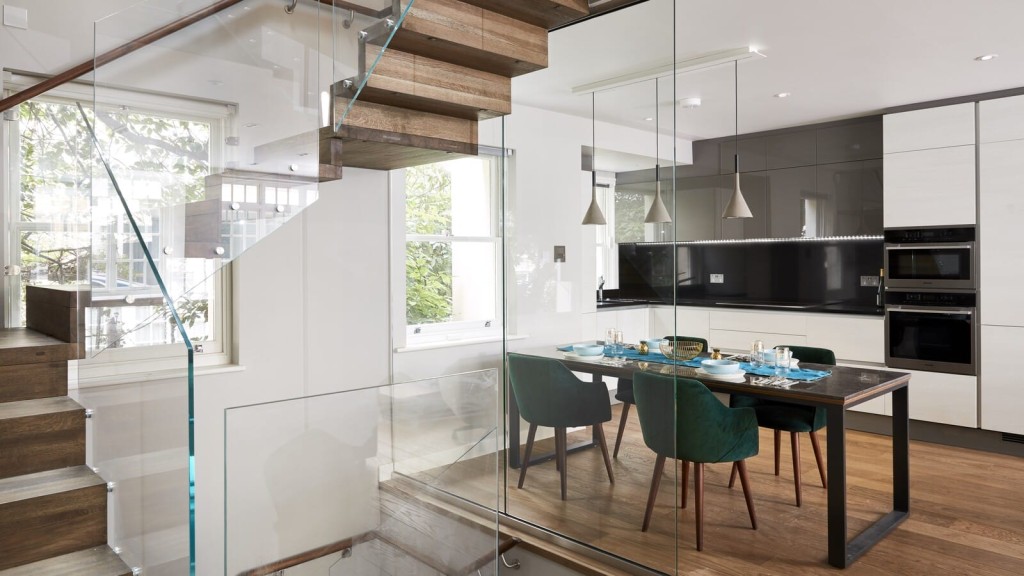 Sleek modern kitchen and dining area with expansive glass walls, creating a luminous and spacious environment. Situated in the prestigious neighborhood of Belgravia, London.