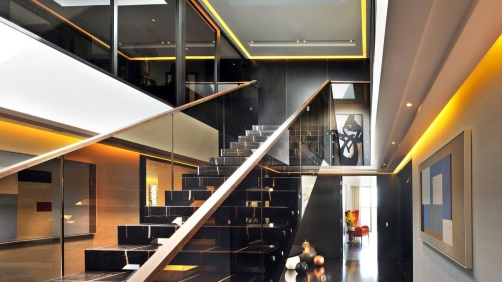 A luxury penthouse interior design featuring a striking black marble staircase with glass railings, ambient lighting, and sleek contemporary decor.