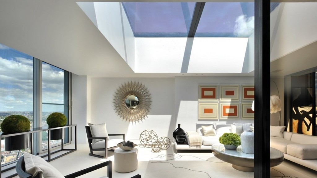 A luxury penthouse interior design with a bright and modern living space, featuring a glass skylight, minimalist furnishings, and panoramic city views.