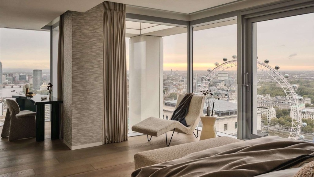 A luxury penthouse interior design featuring a stylish bedroom with floor-to-ceiling windows, offering breathtaking views of the London Eye and city skyline at sunset.