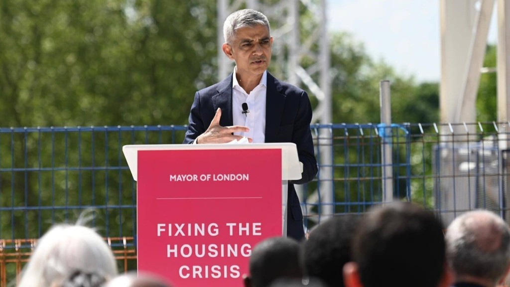 Mayor Sadiq Khan speaking at a podium labelled “Fixing the Housing Crisis,” addressing housing delivery challenges and the need for Green Belt reform in London.