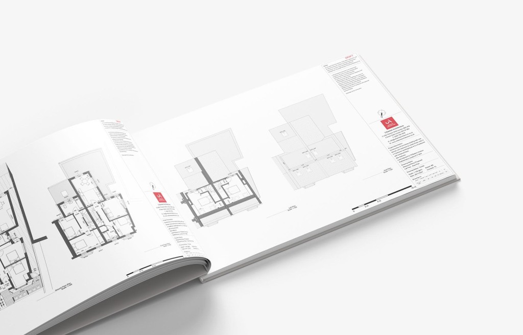 Open architectural planning book displaying detailed floor plans and technical drawings for new homes. The pages feature precise measurements, layout configurations, and annotations, illustrating the comprehensive design process involved in residential construction projects.