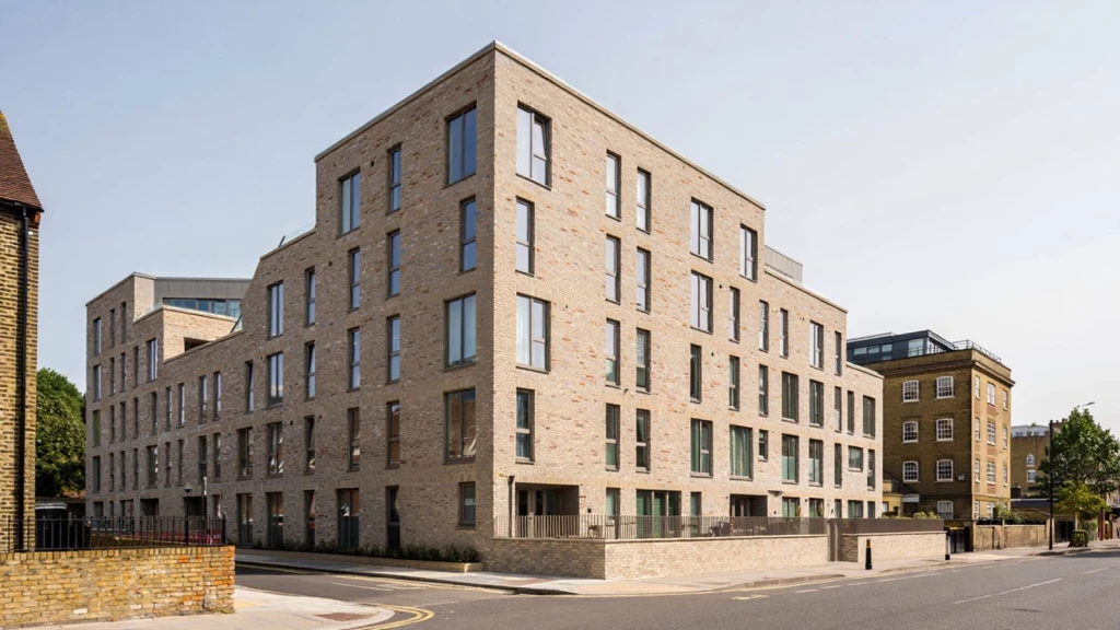 Contemporary brick apartment building in London featuring portrait windows, recessed entrances and stepped massing, exemplifying New London Vernacular residential architecture.