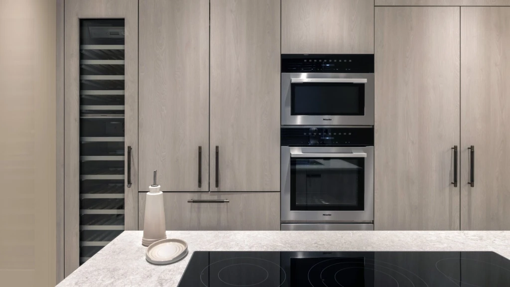 Modern luxury kitchen with bespoke cabinetry, built-in Miele appliances, integrated wine storage and minimalist high-end interior design finishes.