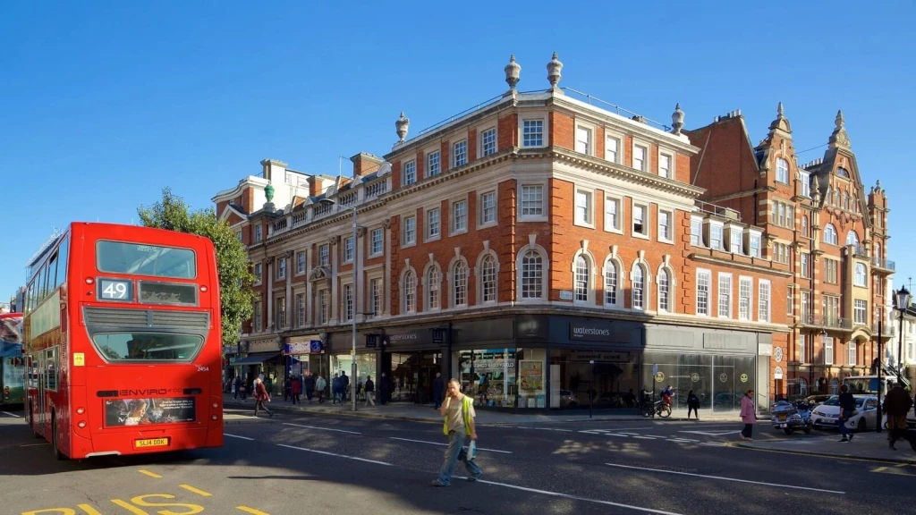 London streetscape with red double-decker bus passing a prominent corner building, representing the real-world planning context where appeal decisions are tested under the revised UK planning appeal system.
