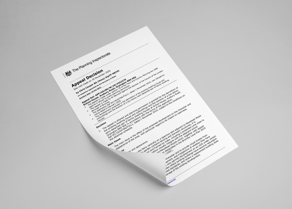 A printed Appeal Decision letter from The Planning Inspectorate on a white paper with detailed text, angled on a grey background, indicating a formal process in the field of urban planning and development law.