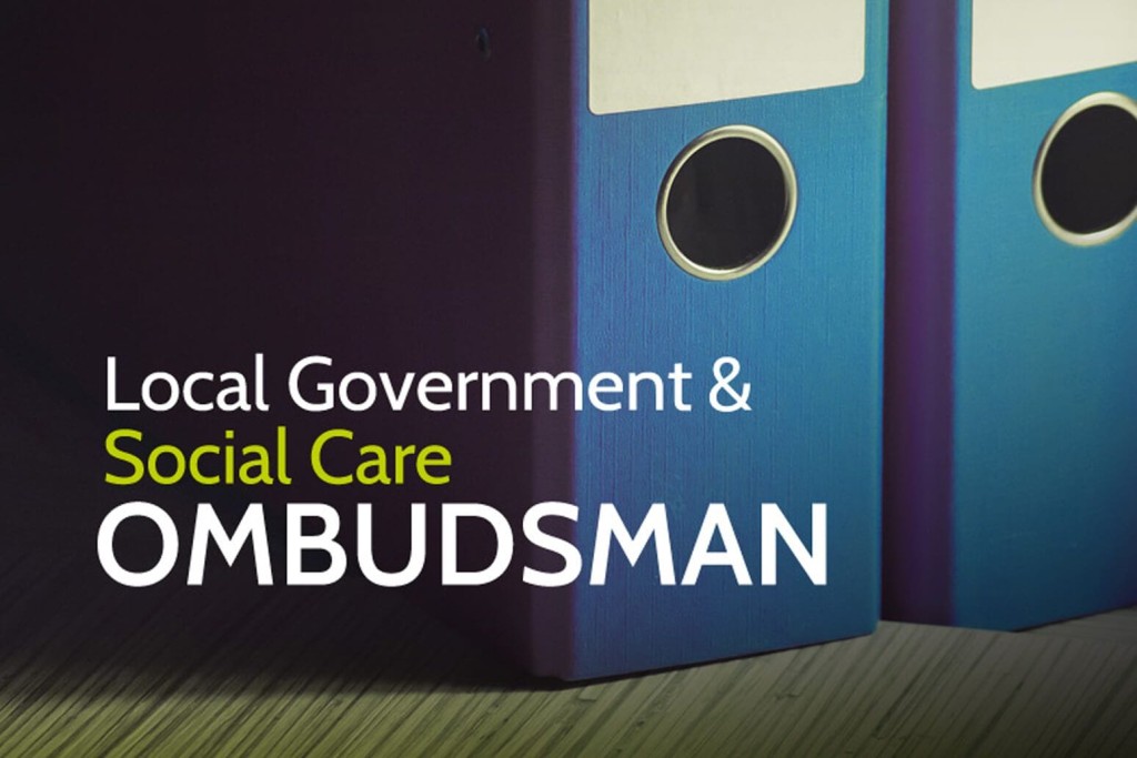 Two binders labeled 'Local Government & Social Care OMBUDSMAN' on a desk, indicating resources or documentation related to official government and social services oversight in the UK.