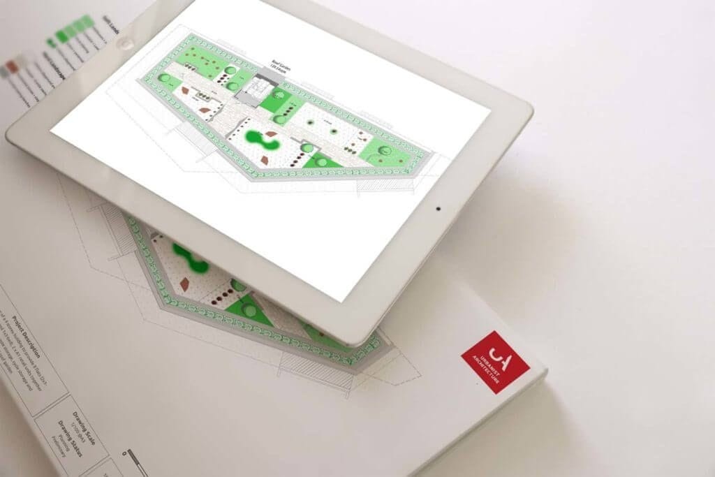 iPad displaying a landscape architecture plan with green space layout on the Urbanist Architecture digital platform, placed on top of related printed construction plans.