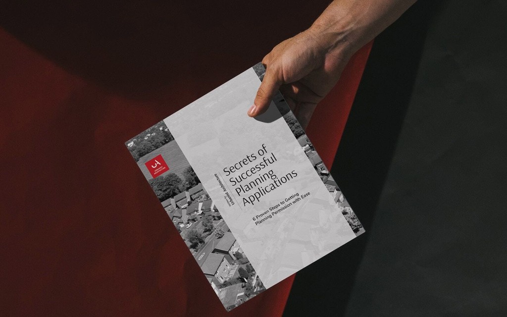 Right hand holding onto the top right of the printed eBook titled Secrets of Successful Planning Applications: 6 Proven Steps to Getting Planning Permission with Ease by Urbanist Architecture