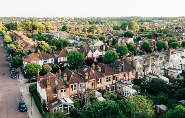 Image cover for the article: Aerial view of a lush greenbelt land in the countryside with a small village, agricultural fields, and allotment gardens, illustrating rural land use and community planning.