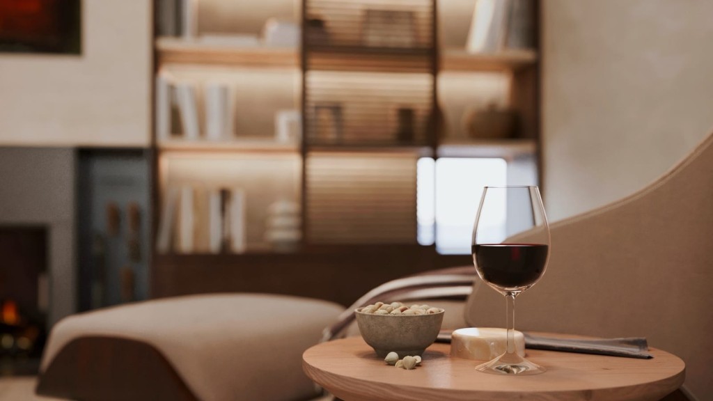 Close-up of a glass of red wine and a bowl of pistachios on a wooden side table, with a soft-focus background of a cozy living room with a lit fireplace and elegant bookshelves, creating a luxurious and relaxed ambiance.
