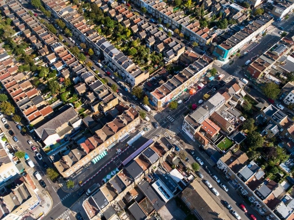 Aerial photograph of a densely populated urban neighbourhood featuring rows of residential houses and commercial properties, illustrating the opportunities for converting shops into homes under new Class E to Class C3 permitted development rights in England.