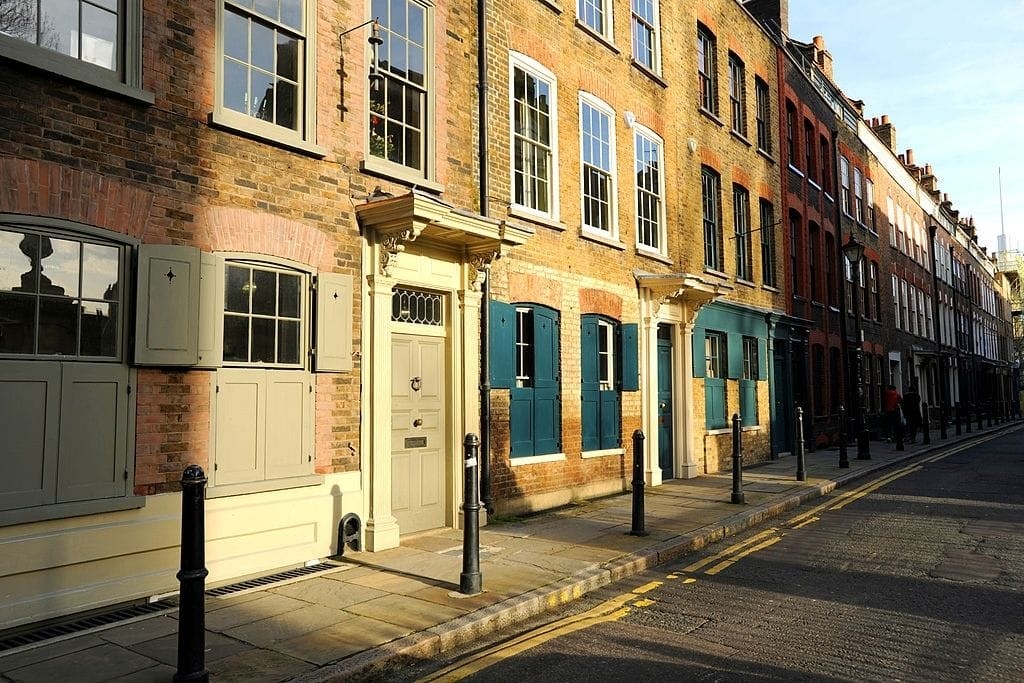 A row of beautifully renovated historic buildings with colorful doors and windows on a quiet street, showcasing the successful conversion of former commercial properties into residential homes, exemplifying the impact of new permitted development rights in England.