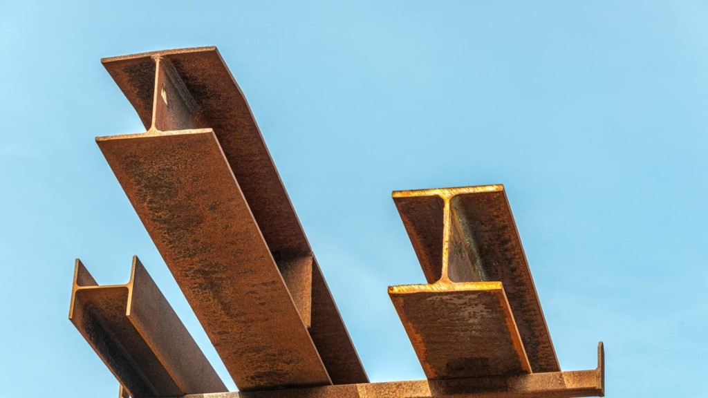 Close-up of weathered steel I-beams against a clear blue sky, symbolizing structural engineering and architectural strength, commonly used in construction and infrastructure projects.