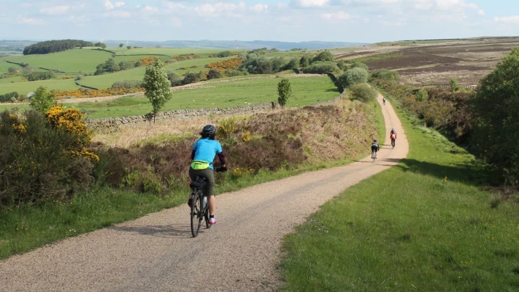 Cyclists on a rural path through UK countryside, illustrating safe walking and cycling routes that support Grey Belt sustainable location assessments.
