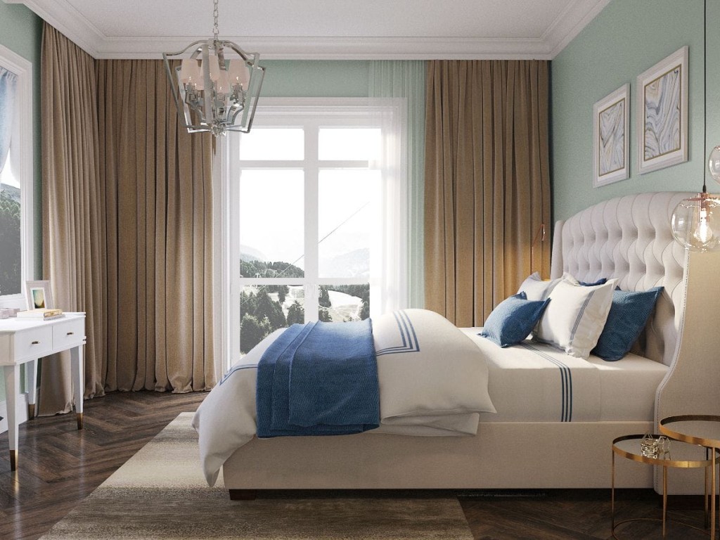 Elegant bedroom featuring a luxurious tufted headboard, crisp white bedding with blue accents, long flowing curtains, a classic chandelier, and framed wall art, with a view of a mountain landscape through the window, reflecting high-end interior design aesthetics.