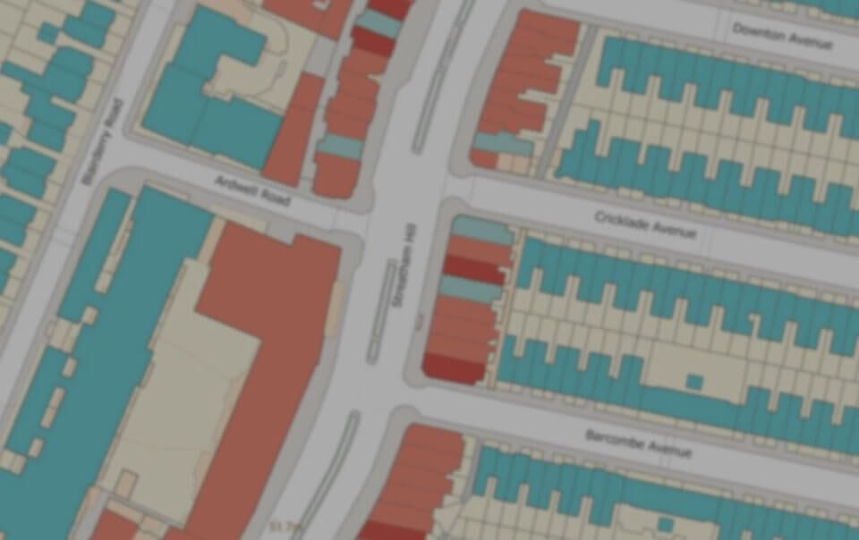 Blurred image of a detailed urban planning map indicating various land uses with color-coded buildings along named avenues, highlighting the planning strategy for a residential neighborhood.