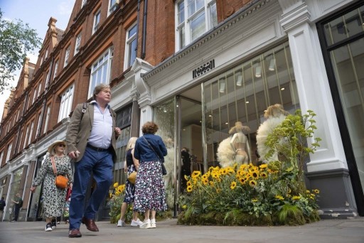 High street view of local Chelsea residents and tourist as they window shop and admire the beautiful Chelsea flowers