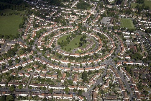 Aerial view on a sunny day of a large residential area which has been developed at its centre in the shape of a circle consequently forming all semi-detached homes and their attached gardens around it