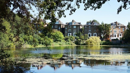 View of the typical street beautiful architecture of Hampstead across from a Hampstead Heath pond
