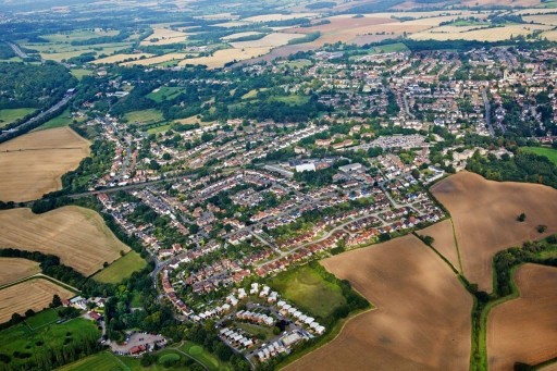 Aerial view of Havering showcasing the unique blend of urban development with residential areas, verdant parks, and surrounding agricultural fields, illustrating the special character of this diverse borough.