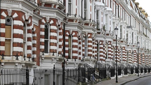 Close-up view of Kensington's iconic red brick and white stone Victorian townhouses, featuring ornate architectural details and iron railings. The row of elegant, historic homes exemplifies the distinctive residential architecture that makes Kensington one of London's most picturesque and affluent neighbourhoods.