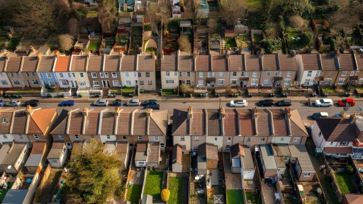 Aerial view of a residential street in Kent showcasing a row of terraced houses with solar panels on rooftops, reflecting sustainable living in suburban England.
